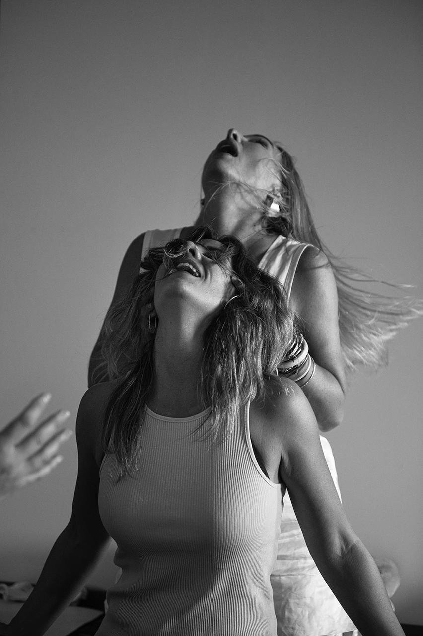Laia Martí, terapeuta y facilitadora de Activación Kundalini, con los ojos cerrados y los brazos alzados, en blanco y negro